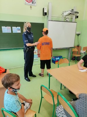 policjantka pokazuje dzieciom jak ubrany jest ratownik
