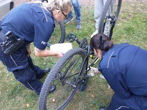 Policjantki znakują rower podczas festynu.