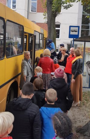 Uczniowie wsiadają do autobusu na terenie ośrodka. Nad wszystkim czuwają policjanci i wychowawcy.