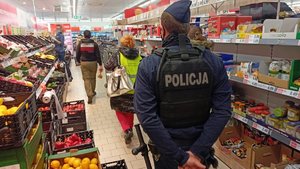 Policjant i pracownik Sanepidu podczas kontroli sklepu spożywczego.