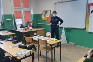 policjantka stoi w klasie i rozmawia z dziećmi