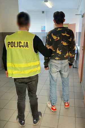 policjant trzyma zatrzymanego