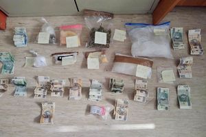 na podłodze leżą rozstawione woreczki z narkotykami oraz pieniądze w gotówce w różnych nominałach