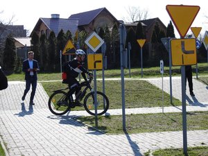 mężczyzna jedzie na rowerze. obok stoją znaki drogowe