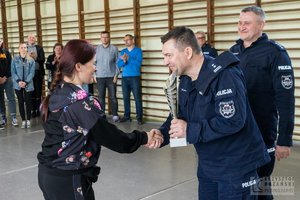 policjant wręcza kobiecie puchar