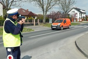 Policjant mierzy prędkość przy drodze