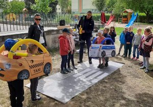 dzieci ćwiczą zachowania na drodze przy pomocy miasteczka ruchu drogowego