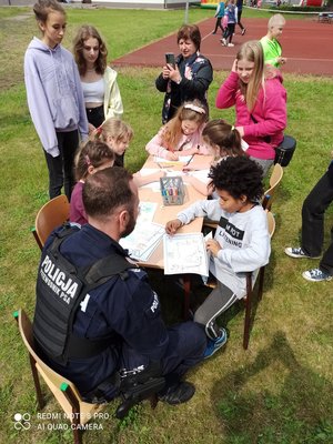 policjant siedzi przy stoliku razem z dziećmi