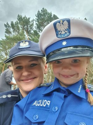 policjantka i dziewczynka przebrana w policyjny mundur.