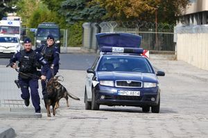 dwoje policjantów biegnących z psami słuzbowymi