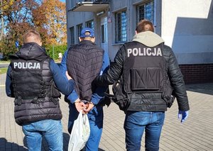 Policjanci prowadzą zatrzymanego.