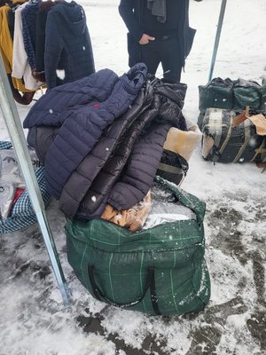 torby z rzeczami leżą na ziemi. Na jednej torbie leży przerzucona kurtka