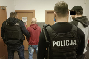 dwaj nieumundurowani policjanci w kamizelkach taktycznych z napisem Policja trzymają po jednym zatrzymanym skutych kajdankami