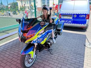 dziewczynka siedzi na policyjnym motocyklu