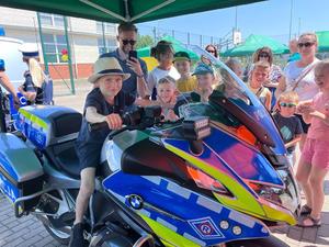 dzieci i dorośli przy policyjnym motocyklu