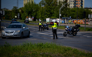 Policjanci wydziału ruchu drogowego podczas działań dotyczących zabezpieczenia przejazdu.