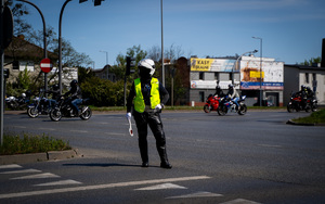 Policjanci wydziału ruchu drogowego podczas działań dotyczących zabezpieczenia przejazdu.