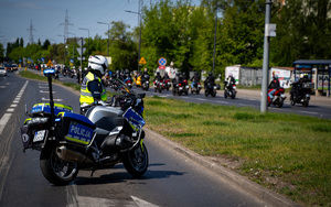 Policjanci wydziału ruchu drogowego podczas działań dotyczących zabezpieczenia przejazdu.