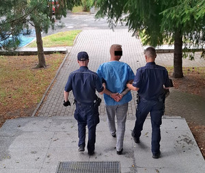 policjanci prowadzą zatrzymanego