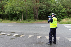 policjant ruchu drogowego mierzący prędkość miernikiem prędkości