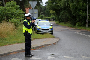 policjant ruchu drogowego mierzący prędkość miernikiem prędkości