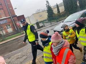 policjant w trakcie przemarszu z dziećmi