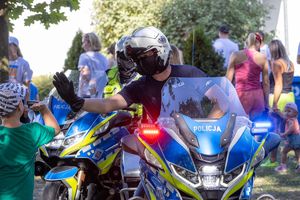 policjant na motocyklu witający się z dzieckiem