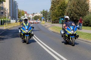 policjanci prowadzący bieg ulicami miasta