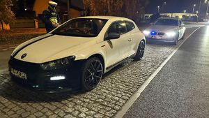 policjant stojący przy zatrzymanym do kontroli pojeździe i wykonuje czynność legitymowania