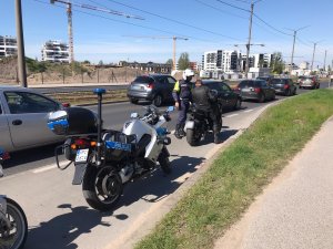 umundurowany policjant kontroluje na drodze motocyklistę