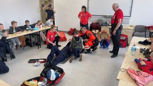 dzieci uczą się pierwszej pomocy od ratowników wopr