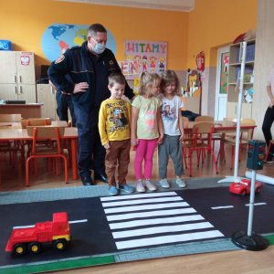 strażnik uczy dzieci przejścia przez pasy