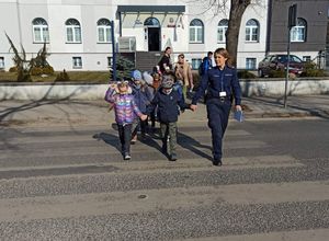 policjantka przeprowadza dzieci przez przejście dla pieszych