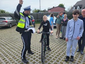 policjant pokazuje uczniowi na rowerze, że może ruszać