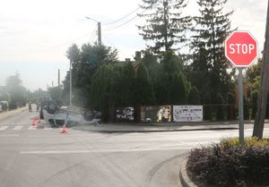 znak stop a w tle auto po dachowaniu