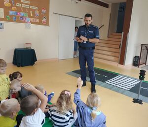 Policjant tłumaczy dzieciom zasady bezpieczeństwa