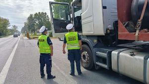 policjant i funkcjonariusz ITD stoją przy otwartych drzwiach ciężarówki