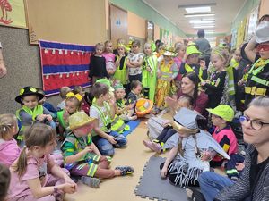 przedszkolaki siedzą na podłodze i oglądają wystepy