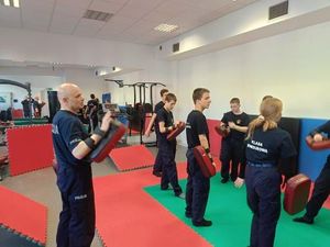 policjanci i uczniowie ćwiczą pchnięcia