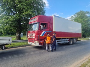 policjantka i pracownik kolei podchodzą do kierowcy ciężarówki