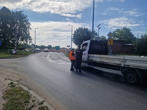 policjantka i pracownik kolei rozmawiają z kierowcą busa stojącego przed przejazdem kolejowym