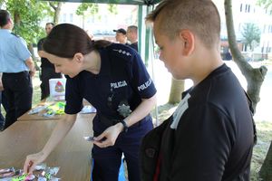 Policjantka prezentuje dziecku odblaski