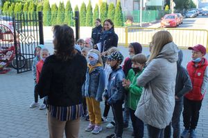 klasy z dziećmi stoją przed budynkiem szkoły