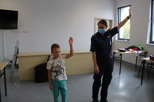 policjantka i chłopiec pokazują lewą rękę