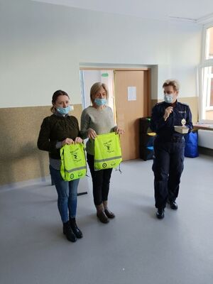 opiekunki dzieci prezentują odblaskowe worki