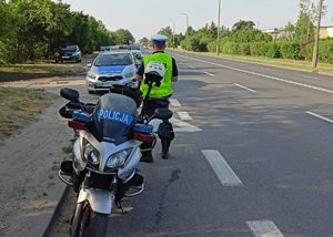widok na policyjny motocykl radiowóz i policjanta