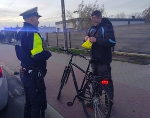 rowerzysta otrzymuje kamizelkę od policjanta