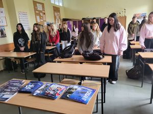 uczniowie na tle ławki z gazetami