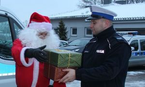 policjant przekazuje paczkę Mikołajowi