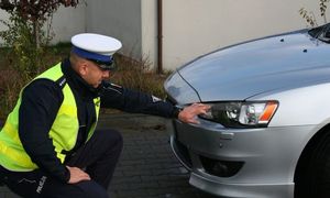 policjant ogląda lampę pojazdu